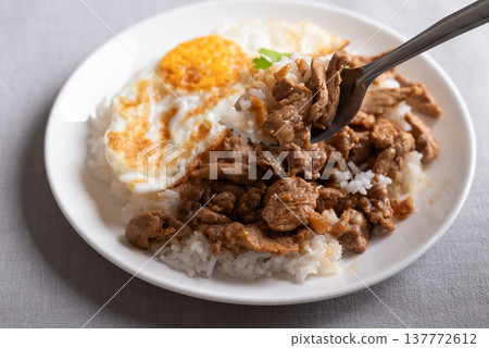 Thai stir-fried pork with garlic, pepper, fried egg and cooked rice  137772612