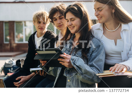 Using digital tablet. Group of students are near university together Using digital tablet. Group of students are near university together 137772734
