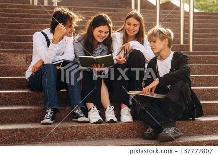 On the stairs, sitting. Group of students are near university together On the stairs, sitting. Group of students are near university together 137772807
