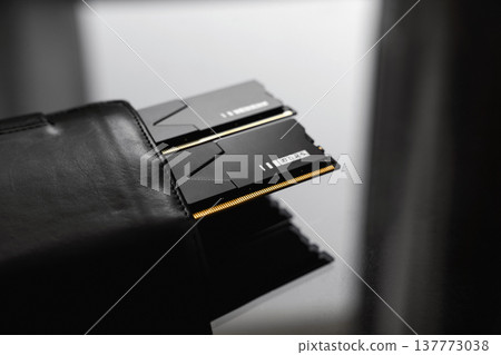 Black DDR5 RAM memory modules placed inside a black wallet on a dark, glossy surface. RAM shortages on the market, rising prices, and increased demand driven by the growing need for AI training. Black DDR5 RAM memory modules placed inside a black wallet on a dark, glossy surface. RAM shortages on the market, rising prices, and increased demand driven by the growing need for AI training. 137773038