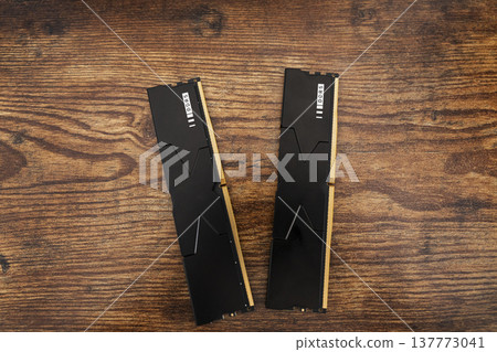 Black DDR5 RAM memory modules placed on a wooden surface. RAM shortages on the market, rising prices, and increased demand driven by the growing need for AI training. Black DDR5 RAM memory modules placed on a wooden surface. RAM shortages on the market, rising prices, and increased demand driven by the growing need for AI training. 137773041