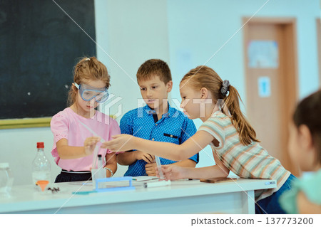 Elementary students conducting a hands-on science experiment together in a classroom lab setting 137773200