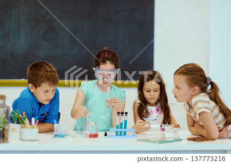 Children conducting a hands-on science experiment in a classroom as classmates observe and learn together 137773216