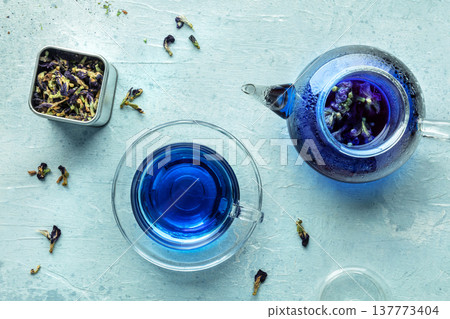 Blue tea, an infusion of butterfly pea flowers. A cup, a teapot, and a tin box Blue tea, an infusion of butterfly pea flowers. A cup, a teapot, and a tin box 137773404
