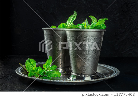 Mint Julep in the Kentucky Derby classic silver glass, with fresh mint leaves Mint Julep in the Kentucky Derby classic silver glass, with fresh mint leaves 137773408
