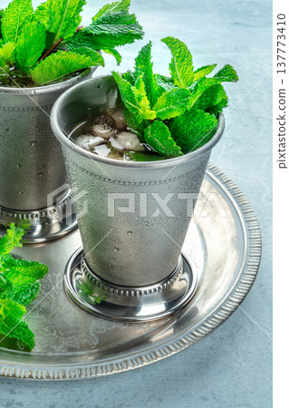 Mint Julep in the Kentucky Derby classic silver glass, with fresh mint leaves Mint Julep in the Kentucky Derby classic silver glass, with fresh mint leaves 137773410