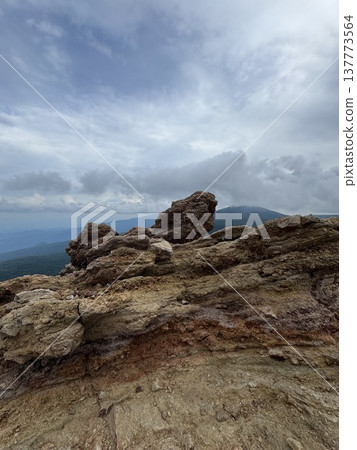 Rock face soaring towards the sky 137773564