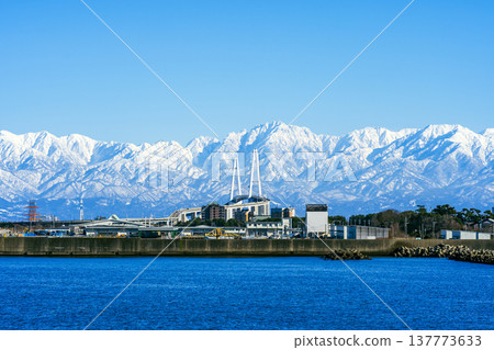 A spectacular view of the Shinminato Bridge and the Tateyama mountain range from the Nagoura Bridge. 137773633