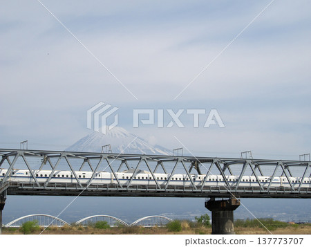 一列新幹線子彈列車駛過鐵路橋，背景是富士山。 137773707