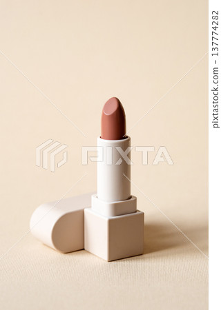Red lipstick on beige background. Makeup product 137774282