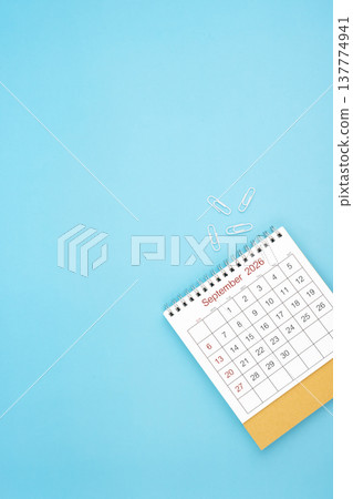 Desk calendar for September 2026 and white paper clip on a light blue background. Desk calendar for September 2026 and white paper clip on a light blue background. 137774941