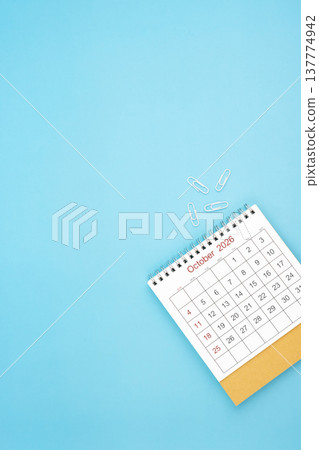 Desk calendar for October 2026 and white paper clip on a light blue background. Desk calendar for October 2026 and white paper clip on a light blue background. 137774942