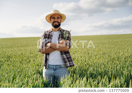 Positive facial expression, smiling. Man farmer is on the agricultural field 137775009