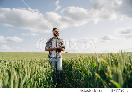 Walking forward. Man farmer is on the agricultural field Walking forward. Man farmer is on the agricultural field 137775032