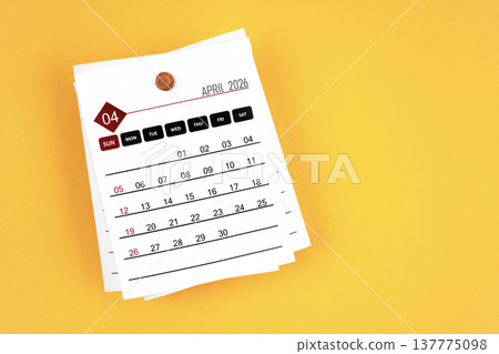 April 2026 calendar page with wooden push pin on yellow, position with copy space. 137775098