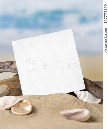 Mockup of blank card on beige sand with seashells, template for beach wedding and event graphics Mockup of blank card on beige sand with seashells, template for beach wedding and event graphics 137775169