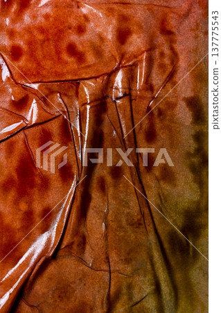 An abstract macro shot of a glossy, burnt orange and brown surface featuring heavy wrinkles, deep creases, and subtle reflections. Ideal for rustic or industrial backgrounds An abstract macro shot of a glossy, burnt orange and brown surface featuring heavy wrinkles, deep creases, and subtle reflections. Ideal for rustic or industrial backgrounds 137775543