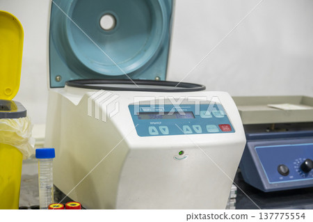 A high-quality image of a medical centrifuge machine in a laboratory setting, used for separating blood samples and other liquids for diagnostic analysis A high-quality image of a medical centrifuge machine in a laboratory setting, used for separating blood samples and other liquids for diagnostic analysis 137775554
