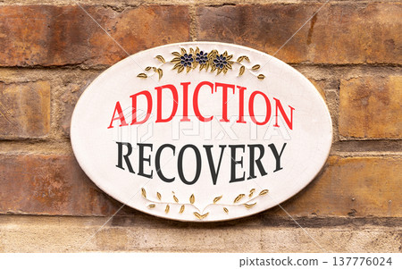 Addiction recovery symbol. Concept words Addiction recovery on beautiful big white sign plate. Beautiful old brown brick wall background. Psychology addiction recovery concept. Copy space. Addiction recovery symbol. Concept words Addiction recovery on beautiful big white sign plate. Beautiful old brown brick wall background. Psychology addiction recovery concept. Copy space. 137776024