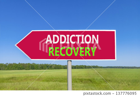 Addiction recovery symbol. Concept words Addiction recovery on beautiful red road sign. Beautiful blue sky green grass field background. Psychology addiction recovery concept. Copy space. 137776095