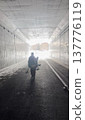 Silhouette of a man heading out of a winter tunnel towards the backcountry 137776119