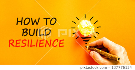 How to build resilience symbol. Concept words How to build resilience on beautiful orange paper. Beautiful orange background. Businessman's hand. Business how to build resilience concept. Copy space. How to build resilience symbol. Concept words How to build resilience on beautiful orange paper. Beautiful orange background. Businessman's hand. Business how to build resilience concept. Copy space. 137776134