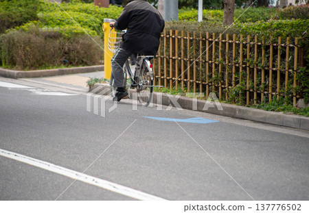 A cyclist riding against traffic on the road. A cyclist riding against traffic on the road. 137776502