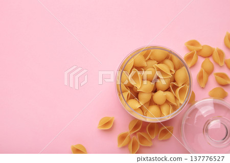 Conchiglie rigate. Raw striped shell pasta in jar on pink background 137776527
