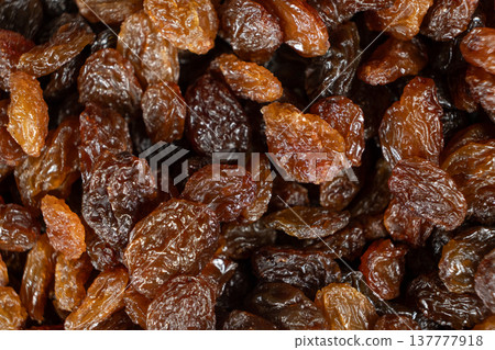 Macro top view of dried grapes, sweet organic raisins. Macro top view of dried grapes, sweet organic raisins. 137777918