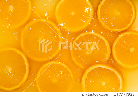 Fresh slices of oranges splashing in orange juice. Fruity bright background Fresh slices of oranges splashing in orange juice. Fruity bright background 137777925