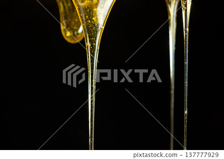 Flowing golden honey with air bubbles texture. Flowing golden honey with air bubbles texture. 137777929