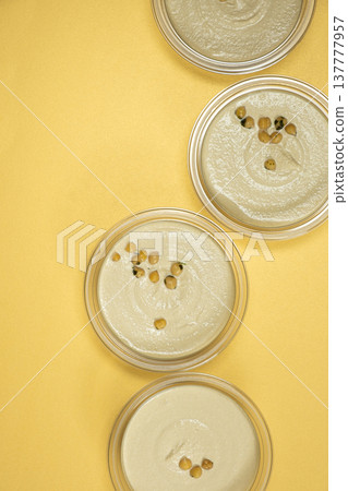 Hummus bowls with whole chickpeas on yellow background. Hummus bowls with whole chickpeas on yellow background. 137777957