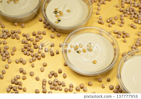 Hummus bowls with whole chickpeas on yellow background. Hummus bowls with whole chickpeas on yellow background. 137777958