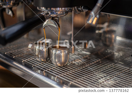 Making coffee by a barista in a coffee machine. The coffee machine makes coffee. Making coffee by a barista in a coffee machine. The coffee machine makes coffee. 137778162