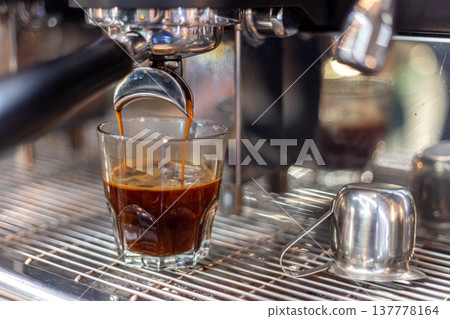 Making coffee by a barista in a coffee machine. The coffee machine makes coffee. Making coffee by a barista in a coffee machine. The coffee machine makes coffee. 137778164