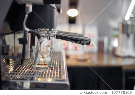 Making coffee by a barista in a coffee machine. The coffee machine makes coffee. Making coffee by a barista in a coffee machine. The coffee machine makes coffee. 137778166