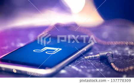 Close up of phone screen with music icon and headphone jack. Close up of phone screen with music icon and headphone jack. 137778309