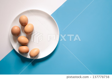 Flat lay, eggs on a white plate on a blue background. Flat lay, eggs on a white plate on a blue background. 137778738