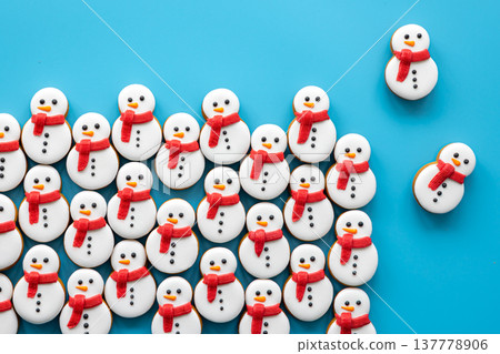 Gingerbread snowmen covered with icing on a blue background, flat lay. Gingerbread snowmen covered with icing on a blue background, flat lay. 137778906