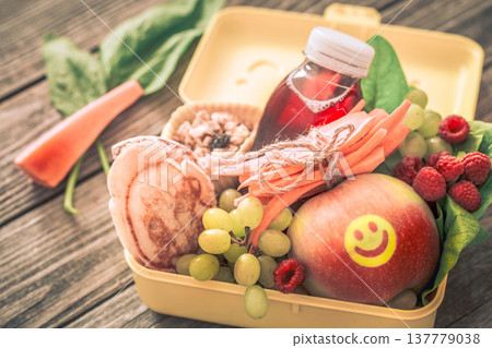 Breakfast or lunch with healthy food in a yellow box, on a wooden background. Breakfast or lunch with healthy food in a yellow box, on a wooden background. 137779038
