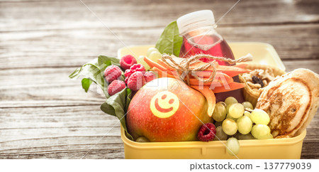 Breakfast or lunch with healthy food in a yellow box, on a wooden background. Breakfast or lunch with healthy food in a yellow box, on a wooden background. 137779039