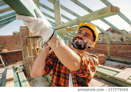 Moving the plank. Construction worker is on the roof of a house Moving the plank. Construction worker is on the roof of a house 137779268