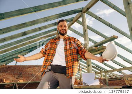 Construction worker is on the roof of a house 137779357