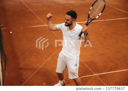 Celebrating victory, happy face. Man is playing tennis indoors in the hangar 137779637