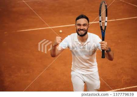 Very happy, smiling, cheerful. Man is playing tennis indoors in the hangar 137779639