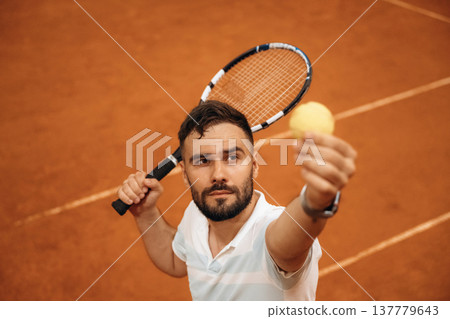 Focused photo on tennis ball in hand. Man is playing tennis indoors in the hangar 137779643