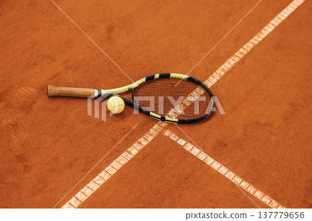 Tennis racket with a tennis ball on a tennis court Tennis racket with a tennis ball on a tennis court 137779656