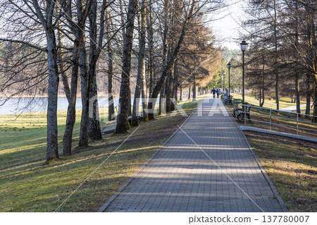 Footpath through a peaceful nature park next to water edge Footpath through a peaceful nature park next to water edge 137780007