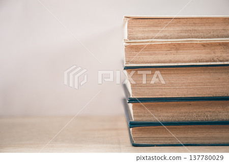 Old books stacked on a white background. 137780029