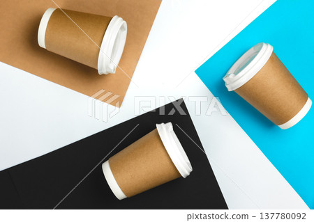 Paper cups on colored paper background, top view. 137780092
